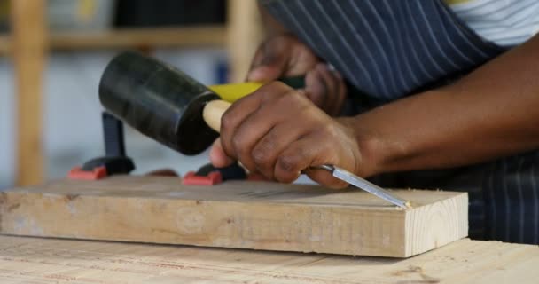 Mid Sectie Van Timmerman Carving Hout Met Hamer Aan Tafel — Stockvideo