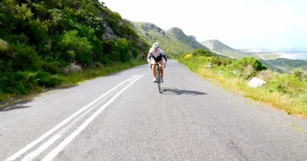 緑豊かな山の の横にある田舎道で若い女性サイクリスト — ストック動画