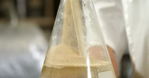 Travailleur masculin versant de l'alcool en fiole à l'usine 4k 