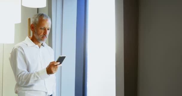 のホテルの部屋で携帯電話を使用して成熟したビジネスマン — ストック動画