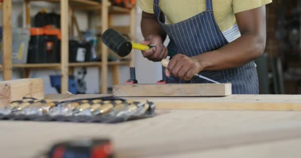 ワーク ショップ でテーブルにハンマーで木材を彫刻大工 — ストック動画