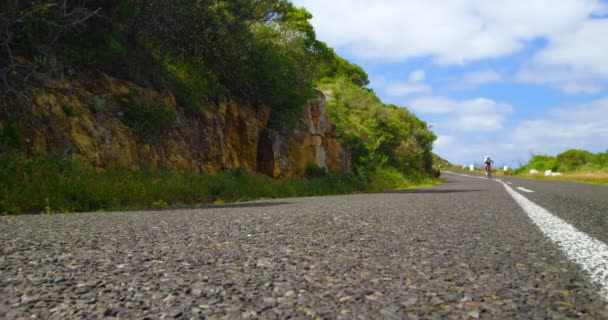 Kvinnlig Cyklist Cykling Landsbygden Väg Bredvid Mountain Rock — Stockvideo