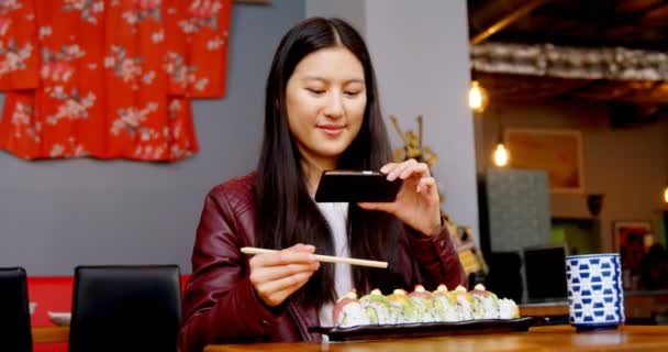 女性寿司レストラン で携帯電話で写真を撮影 — ストック動画
