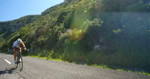 Kvinnlig Cyklist Cykling Landsbygden Väg Bredvid Frodig Mountain Rock — Stockvideo