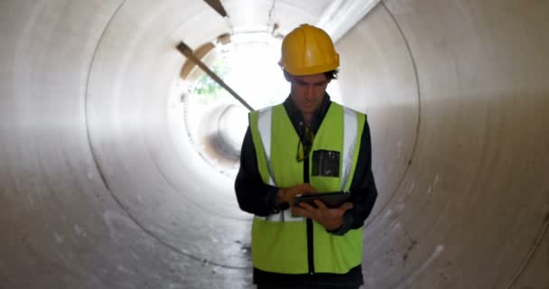 Aufmerksame Männliche Arbeiter Mit Digitalem Tablet Einem Betontunnel — Stockvideo