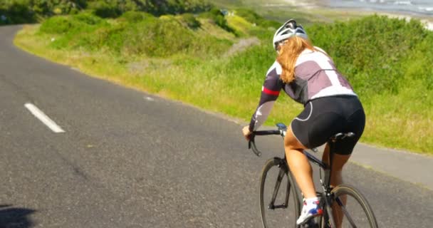 Achteraanzicht Van Vrouwelijke Fietser Fietsen Een Platteland Weg — Stockvideo