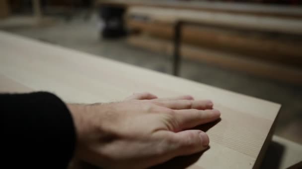 靠近一只白种人男性木匠的手 在一间木材店里触摸和擦拭一块刚切割好的木头 动作缓慢 — 图库视频影像