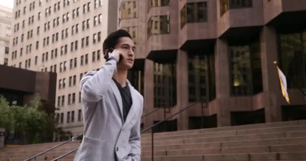 Arka Planda Binalar Ile Şehir Caddesinde Yürüyen Akıllı Telefondan Konuşan — Stok video