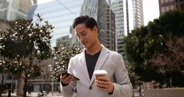 Vista Frontal Joven Mestizo Usando Smartphone Sosteniendo Café Para Llevar — Vídeos de Stock