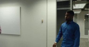 Kafkasyalı bir iş kadınının, modern bir ofisin toplantı odasında durup melez bir iş adamıyla konuşurken kullandığı tablet bilgisayarla onlara katılan Afro-Amerikalı bir adam toplantı odasına giriyor.