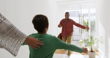 Bir annenin ve melez oğlunun, eve geldiğinde Afrika kökenli Amerikalı babasını selamladıklarını, oğlunun onu selamlamak için güneşin altında ağır çekimde koştuğunu.