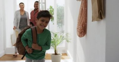 Afrika kökenli Amerikalı bir çiftin ve melez bir oğulun eve gelişinin ön görüntüsü. Sırt çantasıyla koşan oğlu, güneşin altında yürürken gülümsüyor, ağır çekimde.