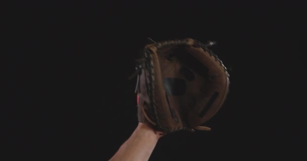 Gros plan de la main levée d'un lanceur ou d'un champ de baseball masculin caucasien, attrapant une balle de baseball dans son gant, ralenti 