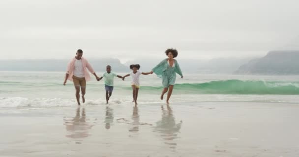 彼らの間の若い息子と娘 スローモーションと手を取り合って 海から離れてビーチで実行しているアフリカ系アメリカ人のカップルのフロントビュー — ストック動画