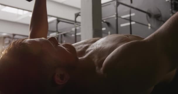 一名赤身裸体的白人运动员躺在体操台上练哑铃 动作缓慢 侧视近景 — 图库视频影像