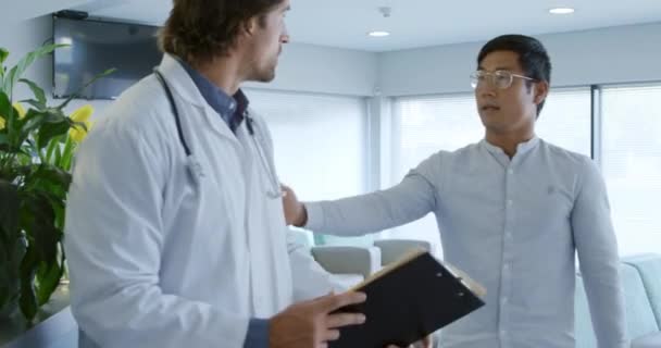 Widok Boku Białego Lekarza Spacerującego Korytarzem Szpitalnym Zatrzymującego Się Uścisnąć — Wideo stockowe