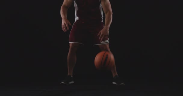 フロントビュー筋肉白人男性バスケットボール選手の低いセクションチームカラーを身に着けている前方に2つの手 スローモーションの間に地面にバスケットボールをバウンスステップ — ストック動画