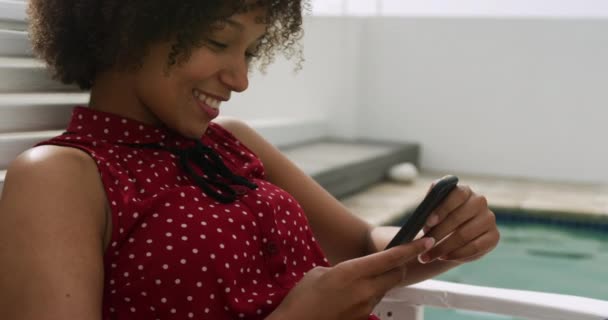 Boční Pohled Zblízka Šťastný Afroameričanka Sedí Bazénu Relaxační Pomocí Smartphonu — Stock video