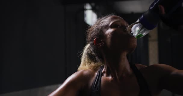 一名身穿运动服的女混血运动员在一家健身房进行交叉训练 站着喝酒 慢动作 — 图库视频影像