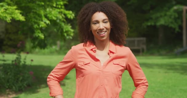 Πορτρέτο Μιας Αφρο Αμερικανίδας Έναν Ηλιόλουστο Κήπο Φορώντας Ένα Πορτοκαλί — Αρχείο Βίντεο
