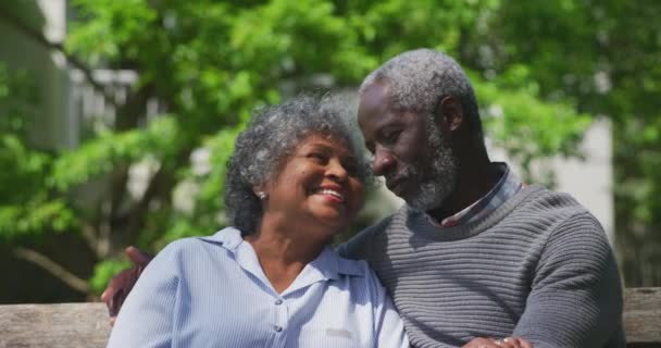 Widok Przodu Zbliżenie Starszej Pary Afroamerykanów Ogrodzie Siedzi Ławce Obejmując — Wideo stockowe