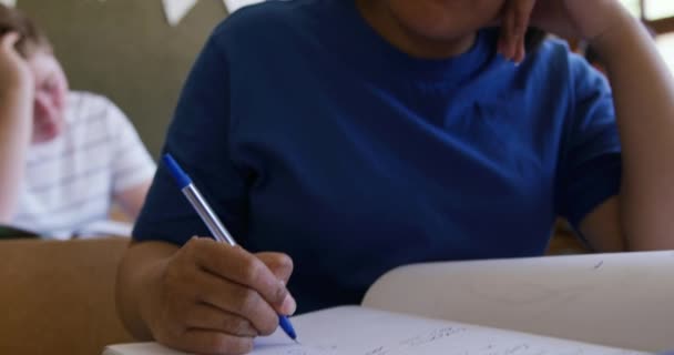 Sınıfta Bir Masada Oturan Eline Yaslanan Defterine Yazan Sınıf Arkadaşlarının — Stok video