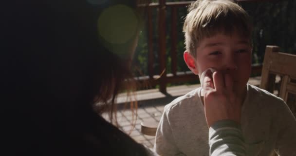 Evdeki Beyaz Bir Çocuğun Görüntüsü Güneşli Bir Masada Terasta Oturuyor — Stok video