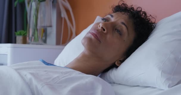 病院のベッドに横たわっ混合レースの女性患者の近くにサイドビューを検索し 背を向けて スローモーション — ストック動画