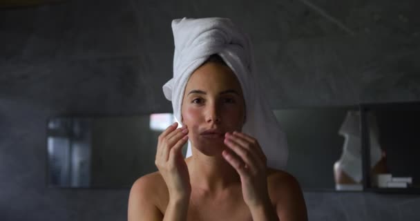 현대적 욕실에서 수건으로 머리카락을 여성의 카메라를 똑바로 쳐다보고 손으로 얼굴을 — 비디오