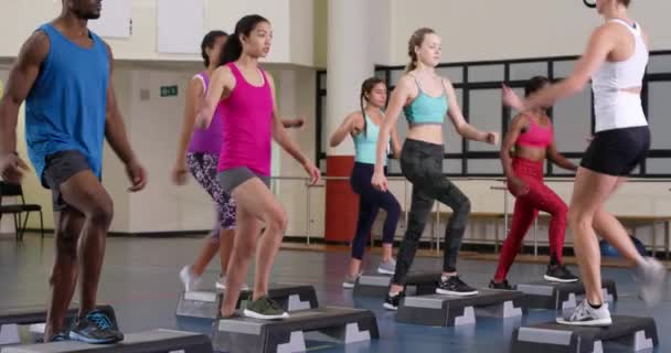 在健身课上 一位卡库阿西亚女性健身教练一边教一群成年人一边走路 一边抬腿 — 图库视频影像