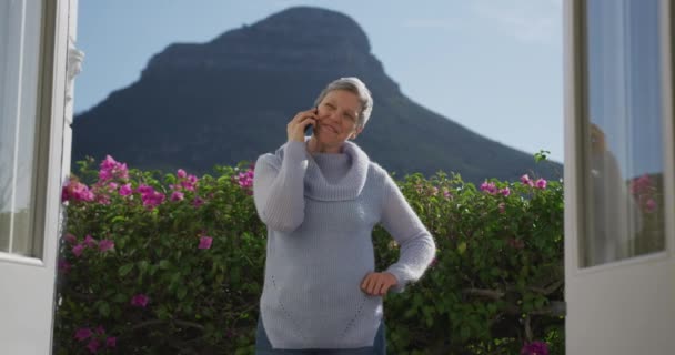 머리를 정원에 카우보이 스웨터를 스마트폰을 할머니의 앞에서 산속을 배경으로 동작으로 — 비디오