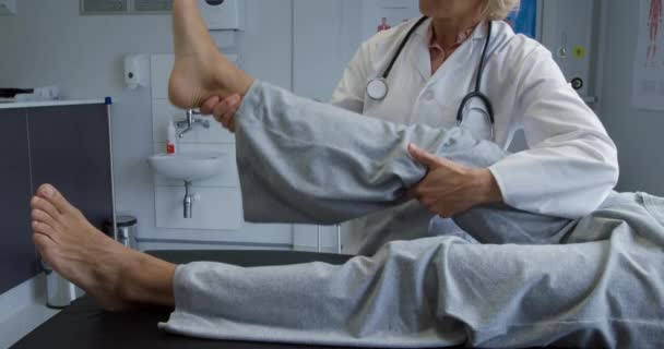 카프카스 실험실 코트를 카프카스 의사가 치료를 무릎을 위아래로 움직이는 환자의 — 비디오