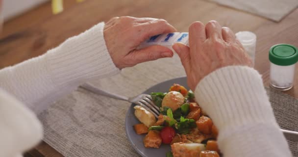 一位年长的白人妇女坐在她家的饭厅里 坐在餐桌旁 从每周的药箱里拿出一片药丸 面前放着一盘叉子和一瓶药丸的熟食 慢动作 — 图库视频影像