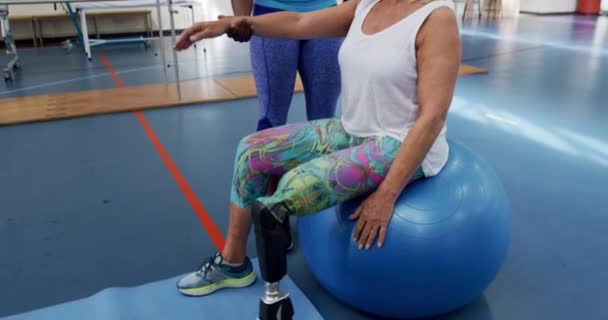 Side View Caucasian Woman Prosthetic Leg Sitting Exercise Ball Sports — Stockvideo