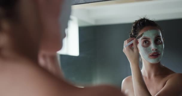 거울을 머리를 코카서스 여성의 너머로 현대적 욕실에서 천천히 붓으로 얼굴을 — 비디오