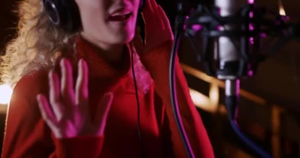 Sarışın Kıvırcık Saçlı Kulaklık Takan Bir Kayıt Stüdyosunda Mikrofona Şarkı — Stok video