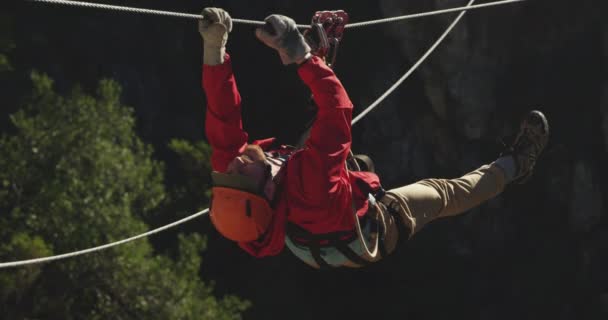 山の中で晴れた日には若い白人男性ジップラインの背面ビューでは ロープを登ると スローモーション 南アフリカでのアドベンチャーバケーション — ストック動画