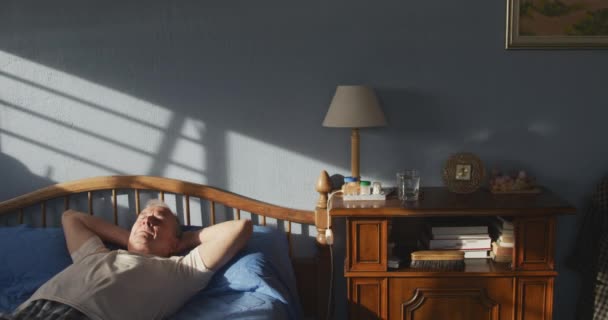 Μπροστά Του Ένας Ηλικιωμένος Καυκάσιος Χαλαρώνει Στο Σπίτι Ξαπλωμένος Ανάσκελα — Αρχείο Βίντεο