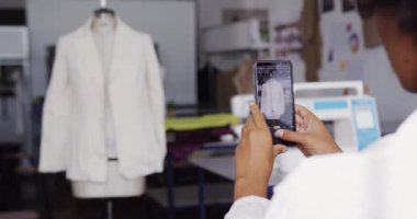 Moda okulunda bir tasarım stüdyosunda çalışan Afrika kökenli beyaz ırktan genç bir kadın moda öğrencisinin ön görüntüsü.