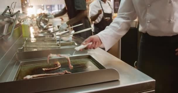 Кавказький Чоловічий Кухар Який Працює Ресторанній Кухні Перевертаючи Смажене Бекон — стокове відео