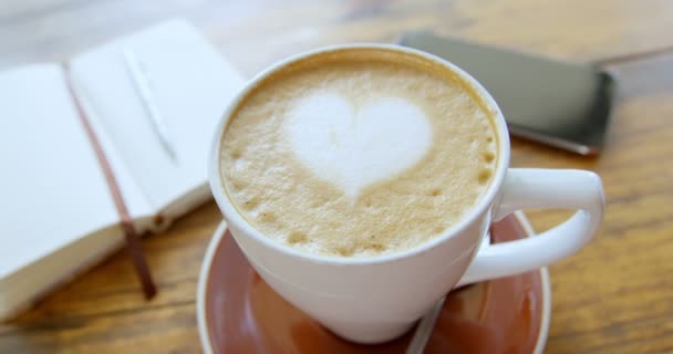 Tasse Heißen Kaffee Latte Mit Herzförmigem Schaumstoff Kunst Mit Tagebuch — Stockvideo