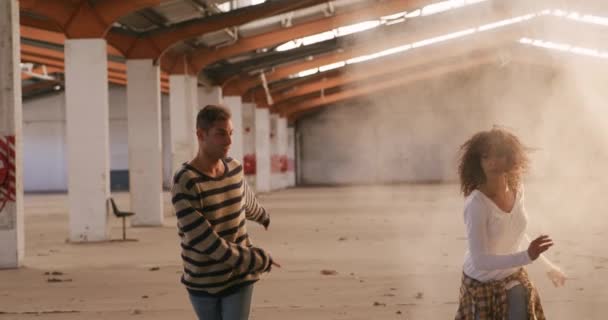 在空荡荡的仓库里一起练习跳舞 慢动作的混血男女舞者的前景 — 图库视频影像