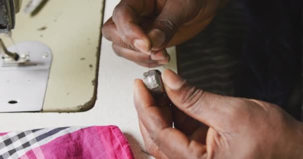 在城镇车间里 一名非洲男性裁缝用缝纫机把线绑在线轴上 慢动作 用手拿着侧视图 — 图库视频影像