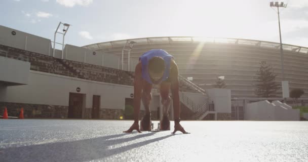 陸上競技場で練習している男女混合の選手のフロントビュー 実行ブロックからスプリントを開始 カメラに実行 スローモーション — ストック動画