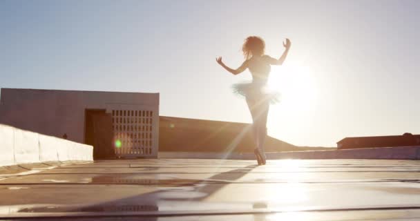 一名混合泳女芭蕾舞蹈演员日出时在屋顶上练习 踮着脚尖走路 慢动作的侧影 — 图库视频影像