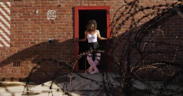 空の倉庫の外で練習混合レースの女性バレエダンサーのフロントビュー 戸口にストレッチ スローモーション — ストック動画