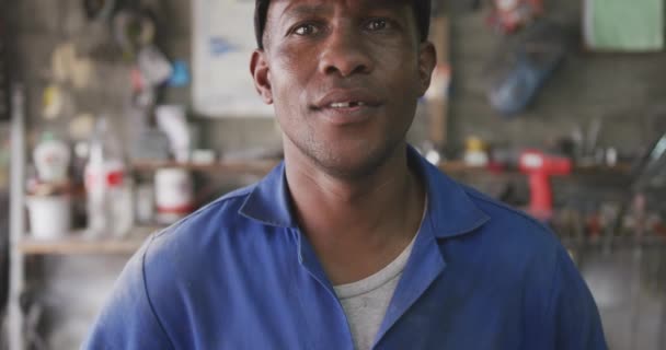 작업장에서 모자를 카메라를 웃으며 느리게 움직이는 아프리카 패널의 — 비디오