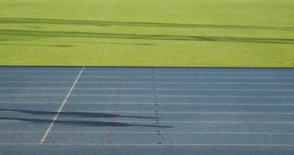 一个白人和混合种族的男性运动员在体育场进行训练 在跑道上赛跑 慢动作的侧视图 — 图库视频影像