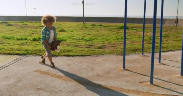 Vista Frontal Menino Raça Mista Aproveitando Tempo Playground Dia Ensolarado — Vídeo de Stock