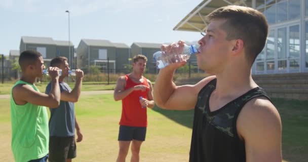 Vista Lateral Grupo Multiétnico Corredores Masculinos Entrenando Campo Deportes Tomando — Vídeo de stock